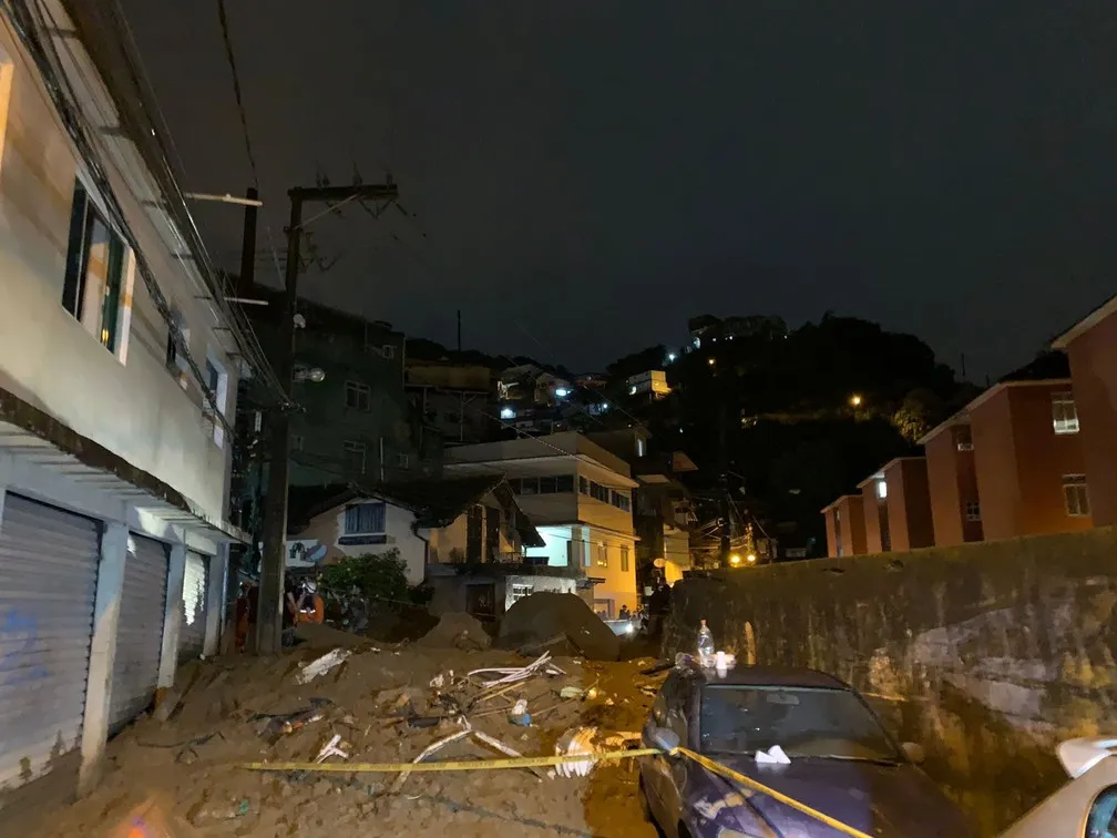 Moradores do Morro da Oficina observam a retirada de mais um corpo dos escombros da região