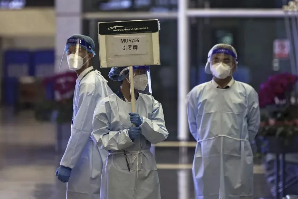 Funcionário da China Eastern segura uma placa esperando para levar parentes das vítimas do voo MU573
