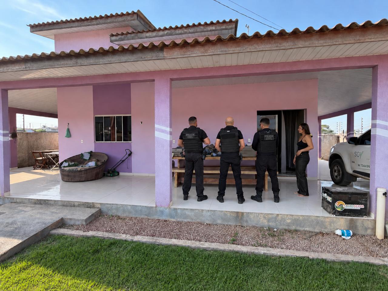 Policiais civis se reúnem na varanda de uma residência durante a operação.