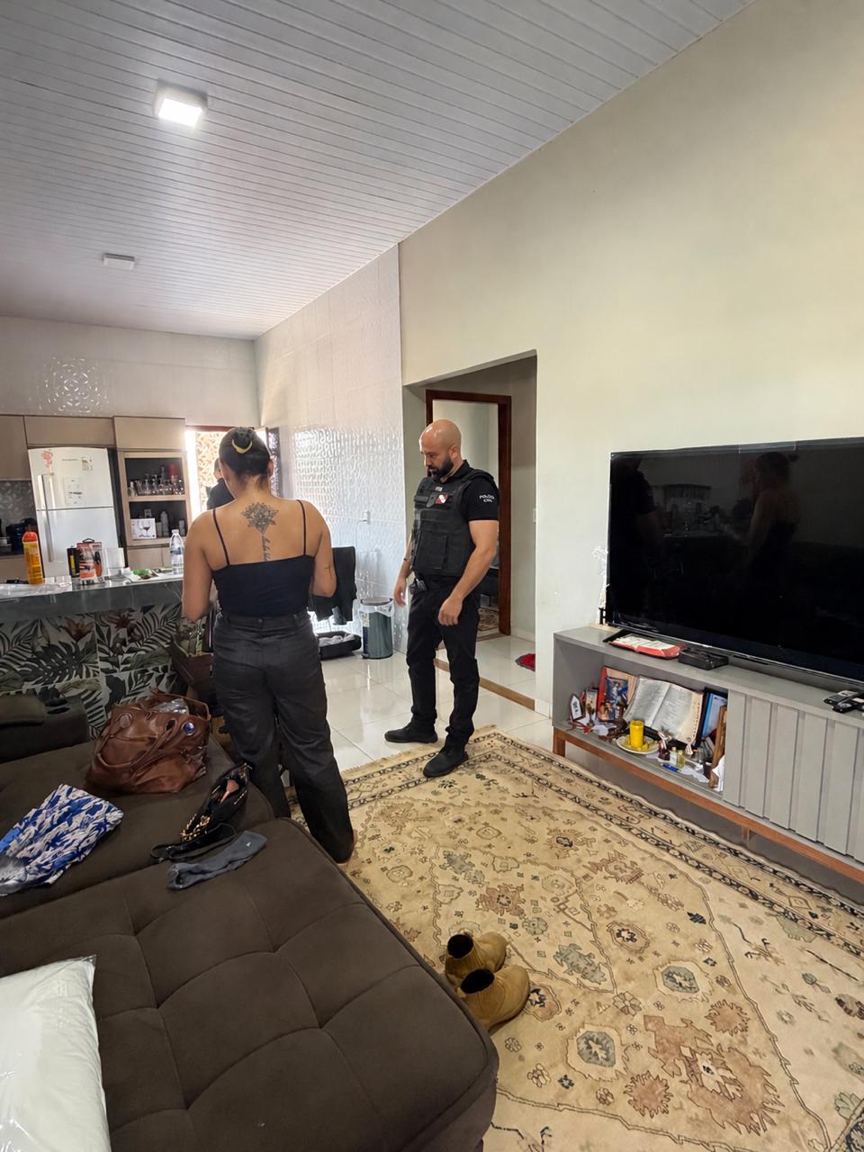 Policial civil acompanha diligência no interior de uma residência.