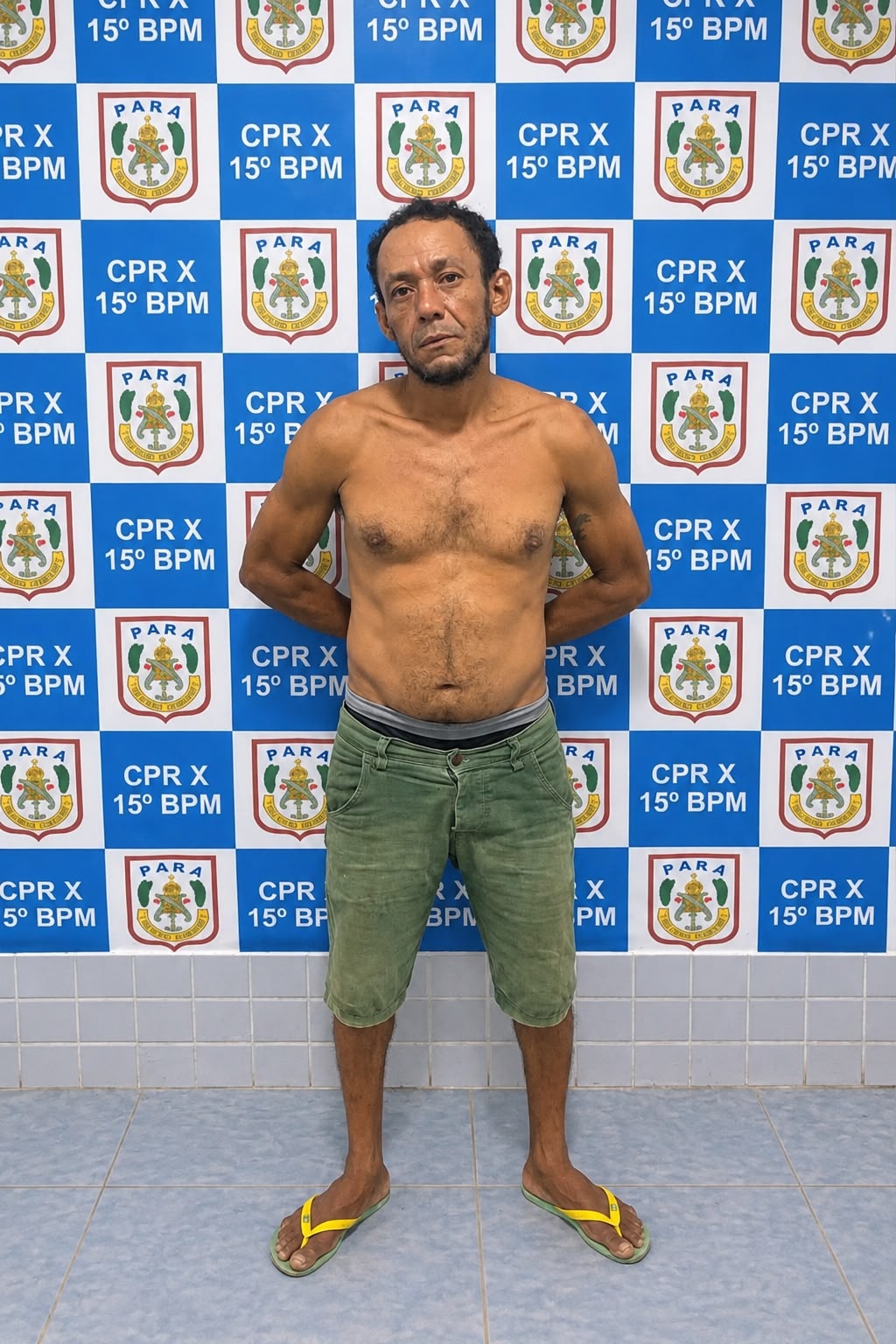 Homem está diante de painel com brasões da Polícia Militar do Pará.